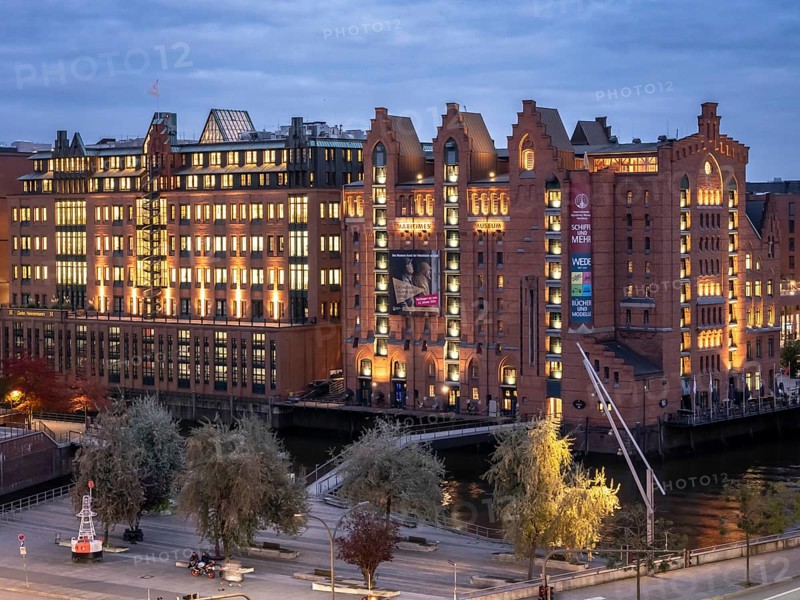 Aerial view of the International Maritime Museum Hamburg surrounded by trees during the blue hour at dusk, Speicherstadt, Hamburg, Germany, Europe