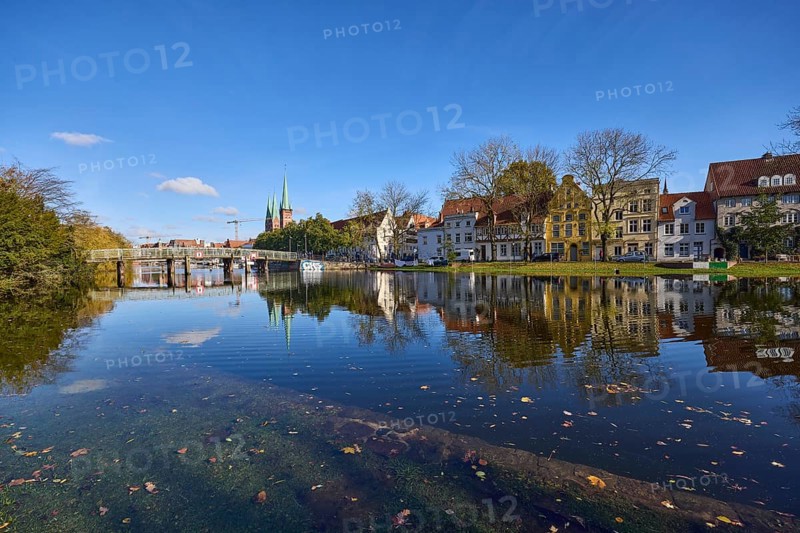 Riverbank of the Trave at high water, pedestrian bridge Dankwartsbrücke, historic houses, trees, reflections on the water surface, blue sky with cumulus clouds, Hanseatic city of Lübeck, independent city, Schleswig-Holstein, Germany, Europe