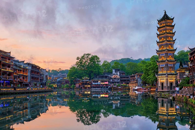 Chinese tourist attraction destination, Feng Huang Ancient Town (Phoenix Ancient Town) on Tuo Jiang River with Wanming Pagoda illuminated at night. Hunan Province, China, Asia