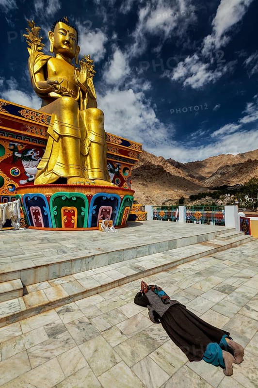 Tibetan Buddhist woman worshiping and praying Buddha Maitreya statue in Likir gompa (monastery), Ladakh, India, Asia