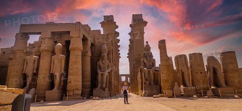 Sculptures of ancient Egyptian pharaohs and drawings on the columns of the Luxor Temple in the evening. Egypt