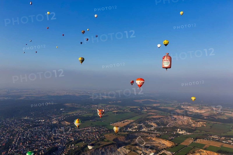Many different hot air balloons in the blue sky, advertising, logo, hot air balloon festival, 26th Warsteiner International Montgolfiade, evening haze, aerial view, Warstein, Sauerland, North Rhine-Westphalia, Germany, Europe