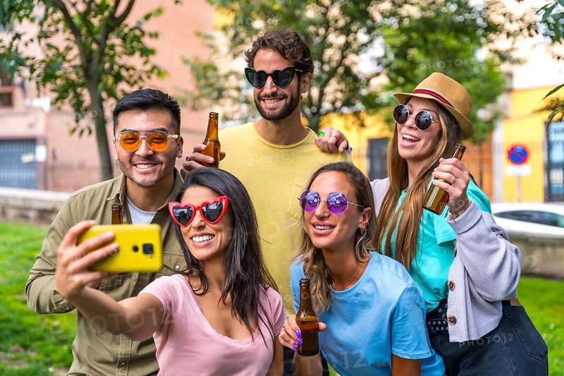 Multi ethnic group of friends partying in the city park taking a selfie, friendship and fun concept with sunglasses