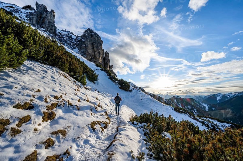 Hikers on a hiking trail with snow, sun star, ascent to Kramerspitz, in autumn, Ammergau Alps, Bavarian Prealps, Bavaria, Germany, Europe