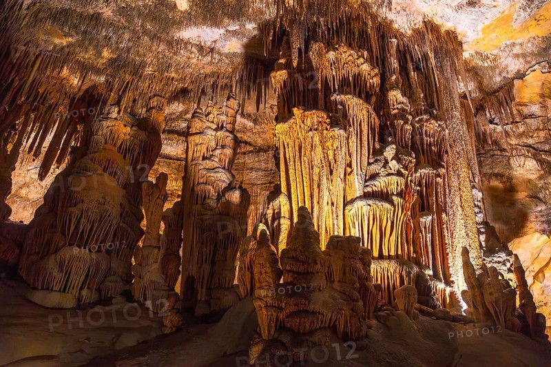 Interior of caves of drach illuminated by colorful lights showing stalactites and stalagmites in mallorca, spain