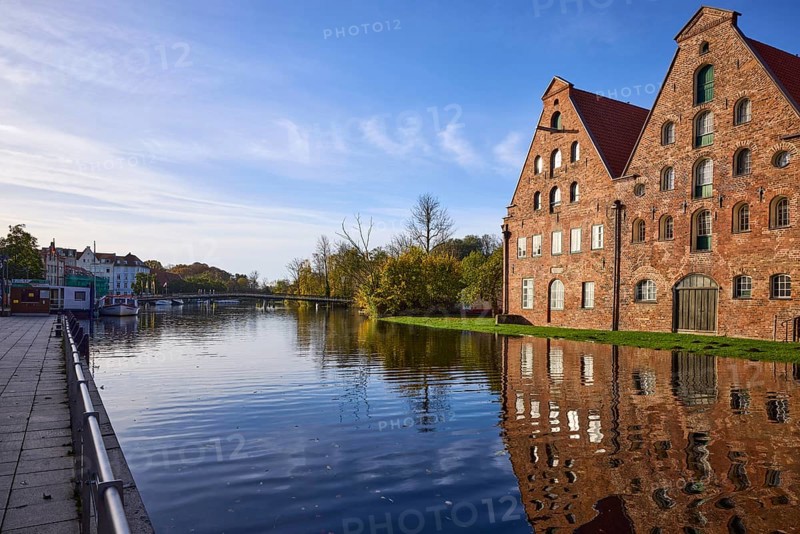 Historic salt warehouses with reflections on the water surface, morning light, Liebesbrücke, Hanseatic City of Lübeck, Schleswig-Holstein, Germany, Europe