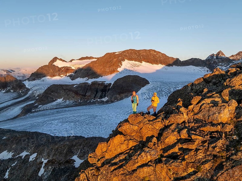 Atmospheric sunrise in a picturesque mountain landscape, alpenglow, aerial view, mountaineer on the summit of Becher and Übeltalferner glacier, Stubai Alps, South Tyrol, Italy, Europe
