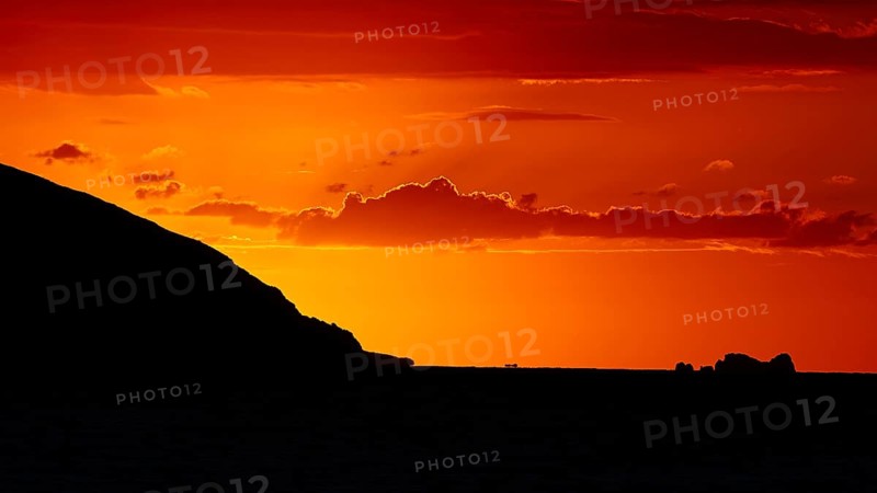 Dramatic sunset over the sea with a silhouetted island and a bright orange sky, sunset, Kassos, Karpathos, offshore islands, Dodecanese, Greek Islands, Greece, Europe