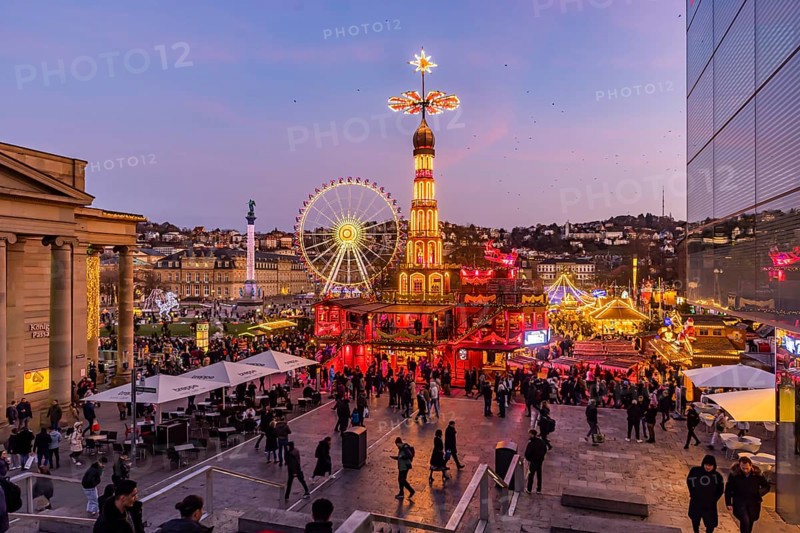 Stuttgart Christmas market at the blue hour. Christmas pyramid on Schlossplatz in front of the New Palace with Ferris wheel. The traditional event attracts more than three and a half million people to the city centre during the Christmas season. Stuttgart, Baden-Württemberg, Germany, Europe