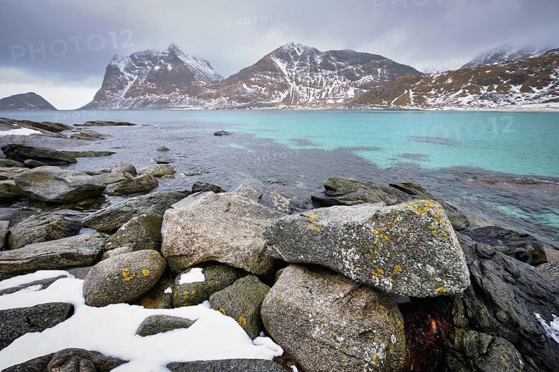 Rocky coast of fjord of Norwegian sea in winter with snow. Haukland beach, Lofoten islands, Norway, Europe