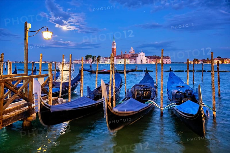Romantic vacation Venice travel background, gondolas at Saint Mark (San Marco) square and Basilica San Giorgio Maggiore Church seen across Venice lagoon with full moon. Venice, Italy, Europe