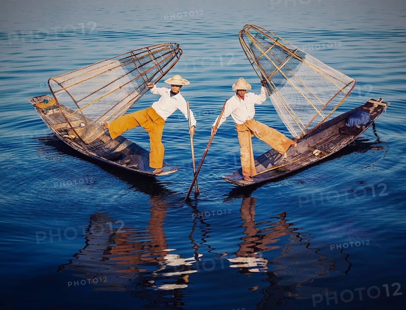 Myanmar travel attraction, Traditional Burmese fishermen balancing with fishing nets at Inle lake in Myanmar. Vintage filtered retro effect hipster style image