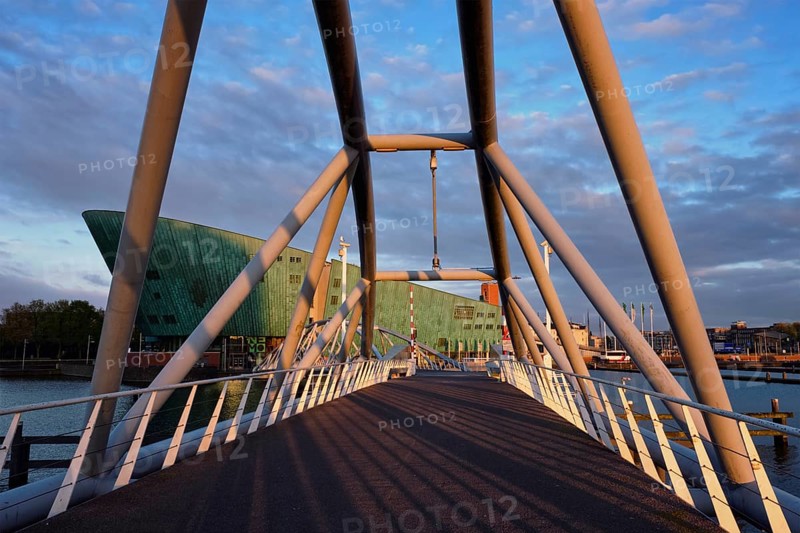 AMSTERDAM, NETHERLANDS, MAY 9, 2017: NEMO Science museum and Mr. J. van der Veldebrug bridge. It is the largest science center in Netherlands with over 500000 visitors per year