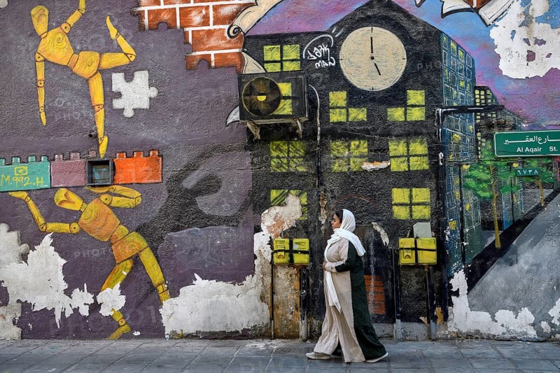 Veiled woman in front of mural, graffito, Al Khobar, ash-Sharqiyya province, Persian Gulf, Saudi Arabia, Asia