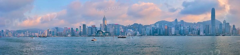 HONG KONG, CHINA, APRIL 28, 2018: Hong Kong skyline cityscape downtown skyscrapers over Victoria Harbour in the evening on sunset with junk tourist boat ferries, Hong Kong, China, Asia