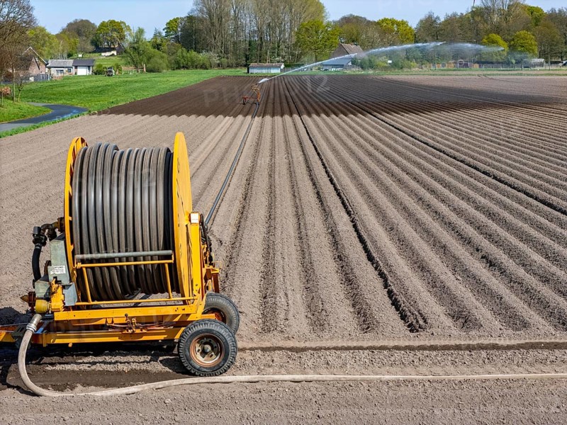 Artificial irrigation of a potato field in April, with a sprinkler system, long drought in spring makes this necessary, for the total of 7.5 hectares 3 full days are needed to get the necessary moisture for the freshly sown potato plants, south of Straelen, Lower Rhine, North Rhine-Westphalia, Germany, Europe