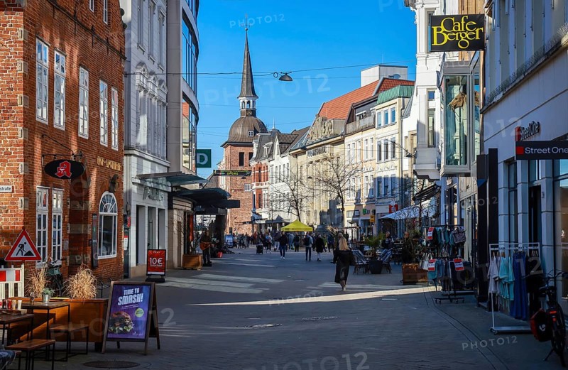 Oldenburg, Lower Saxony, Germany - Historic town centre, here the Lange Straße in the pedestrian zone, behind the Lappan, an old bell tower with a Renaissance dome, a sight in the old town of Oldenburg. The pedestrian zone is characterised by historic buildings, small alleyways, a variety of owner-managed shops and restaurants. On the left the Hof Apotheke