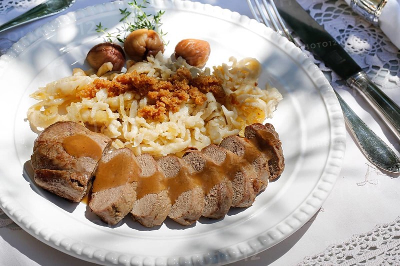 Swabian cuisine, roast venison with spaetzle, chestnuts and breadcrumbs, breadcrumbs, saddle of venison arranged on a plate, gravy, game dish, meat, main course, gravy, cutlery, knife, fork, grandmother's kitchen, regional, home cooking, typical Swabian, traditional cuisine, festive tablecloth, food photography, studio, Germany, Europe