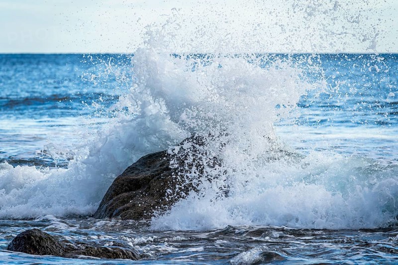 Rocks and sea on the beach of Playa del Inglés. Splashing spray from a wave. Valle Gran Rey, La Gomera, Canary Islands, Spain, Europe
