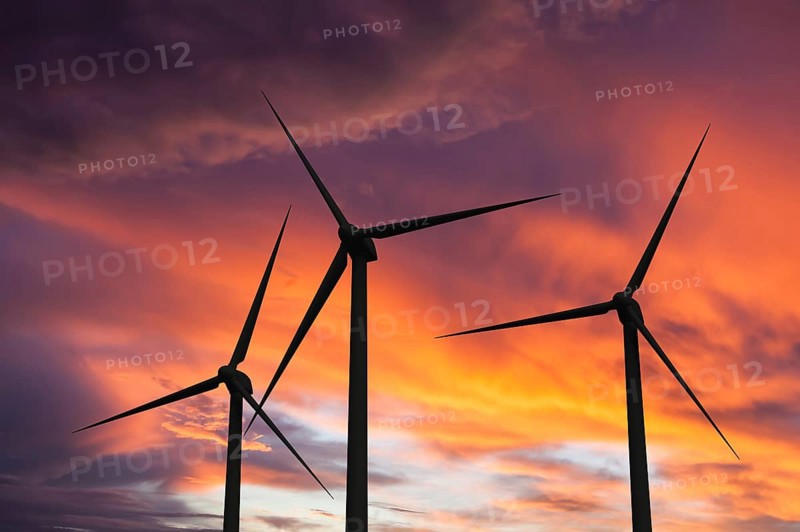 Green renewable energy concept, wind generator turbines in sky on sunset