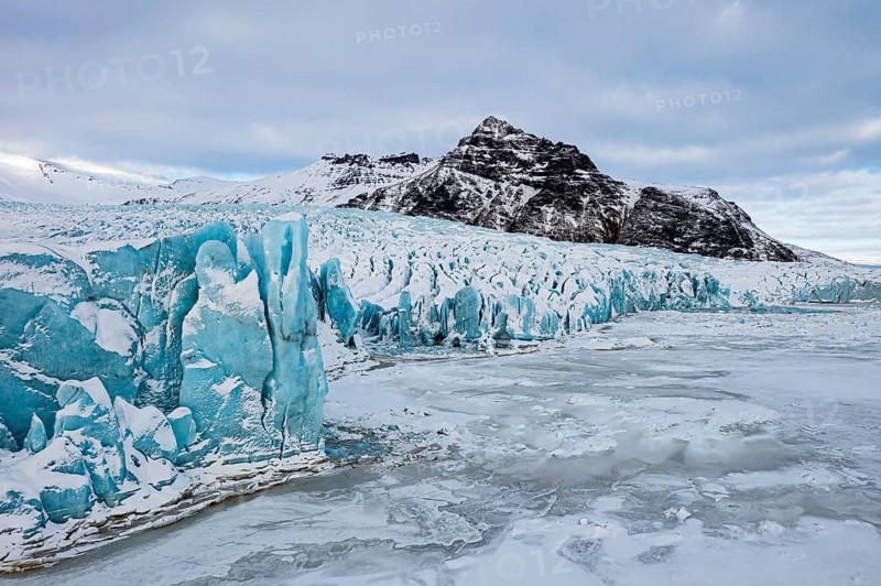 Glacier break-off and snow-covered icebergs in the Fjallsarlon glacier lagoon, with the Öraefajökull glacier in the background, drone shot, Sudurland, Iceland, Europe
