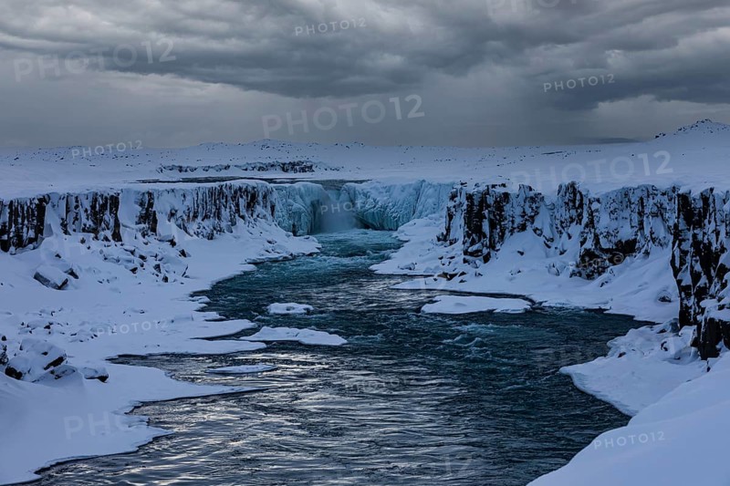 Selfoss waterfall with the river Jökullsa a Fjöllum, icy and snow-covered cliffs and shoreline, Northern Iceland Eyestra, Iceland, Europe