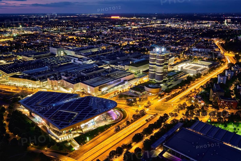 MUNICH, GERMANY, JULY 08, 2018: Aerial view of BMW Museum and BWM Welt and factory and Munich from Olympic Tower illuminated at night. BMW is a famous German luxury car automaker