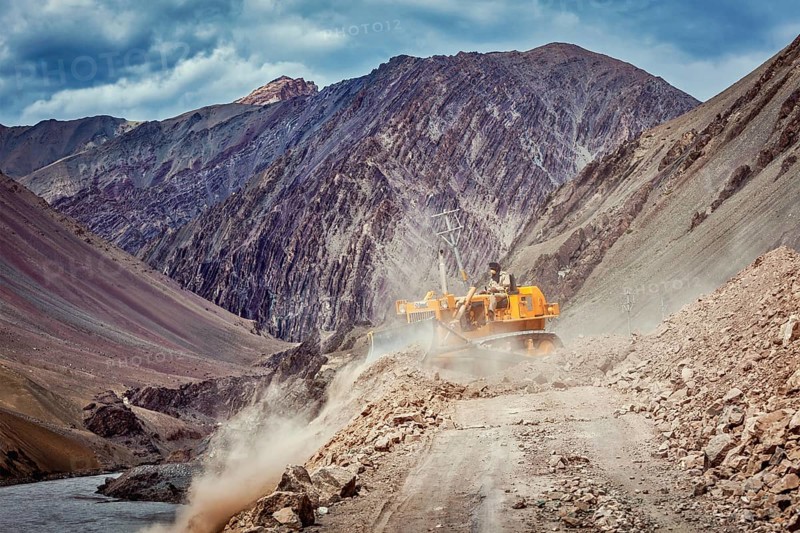 LADAKH, INDIA, SEPTEMBER 10, 2011: Bulldozer cleaning road after landslide in Himalayas. Ladakh, Jammu and Kashmir, India, Asia
