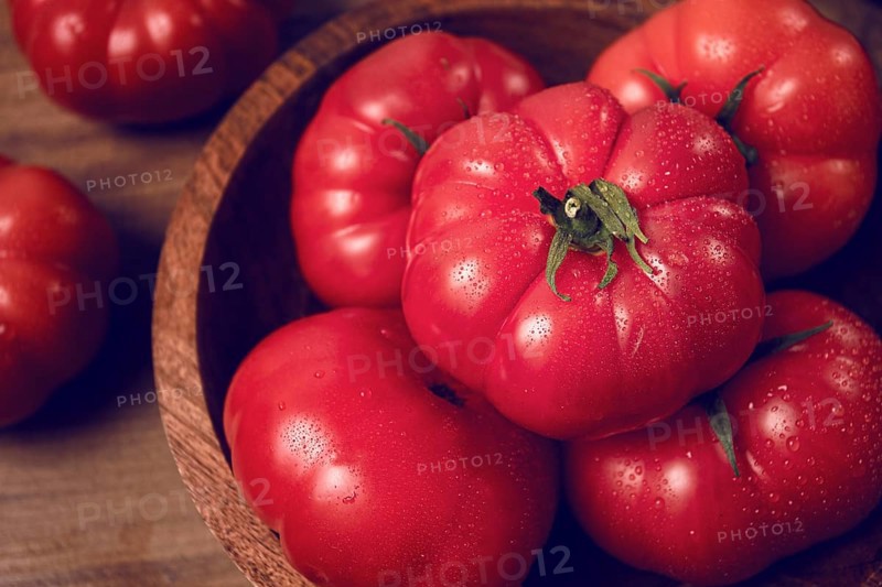 Pink tomatoes, in a rustic wooden bowl, close-up, no people