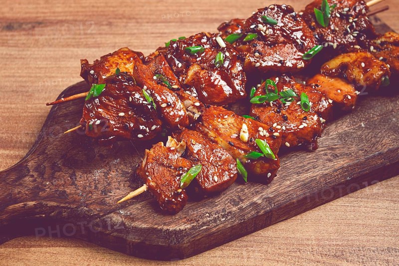 Yakitori chicken kebab, on skewers, with green onions and sesame seeds, top view, without people
