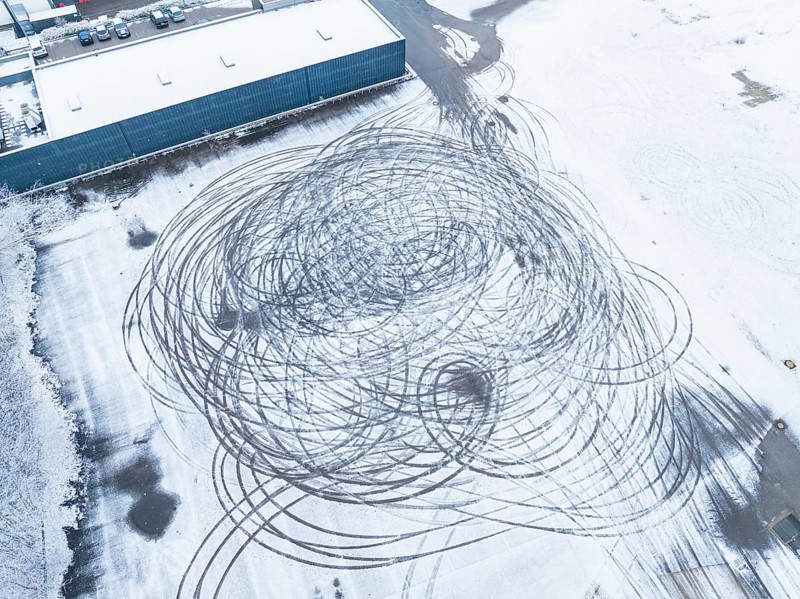 Tyre tracks form large circles on a snow-covered surface as seen from the air, Nagold, Black Forest, Germany, Europe