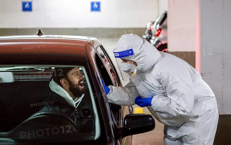 Cologne, North Rhine-Westphalia, Germany - Covid rapid test in a car park, at the Medicare test centre, customers drive up to the drive-in counter for sampling (staged scene)