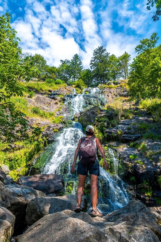 A female backpacker in summer at the Todtnau waterfall in the Black Forest in Germany