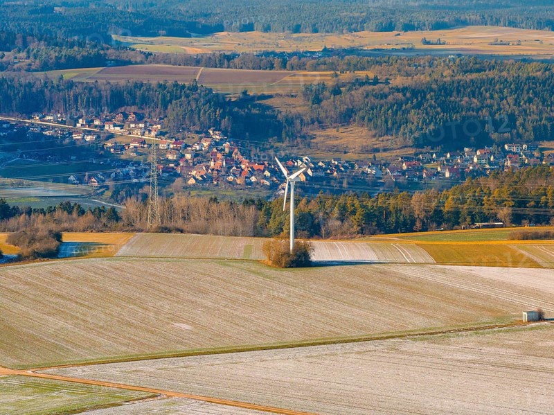 A wind turbine stands in a frosty landscape with a village in the background, district of Calw, Germany, Europe