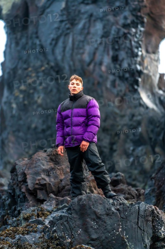 Portrait of an adventurous young man on Djupalonssandur beach in winter in Iceland