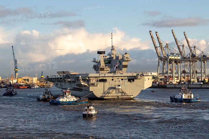 Harbour tug and aircraft carrier HMS Queen Elizabeth, warship of the British Royal Navy on the river Elbe arriving for a NATO exercise in the port of Hamburg, Germany, Europe