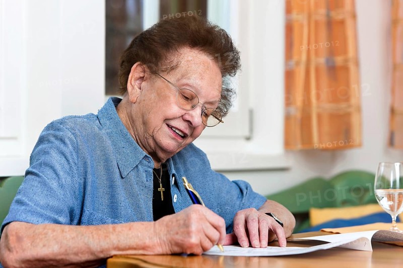 An old woman signs a letter, 75, 80, years, senior studio shot, Federal Republic of Germany
