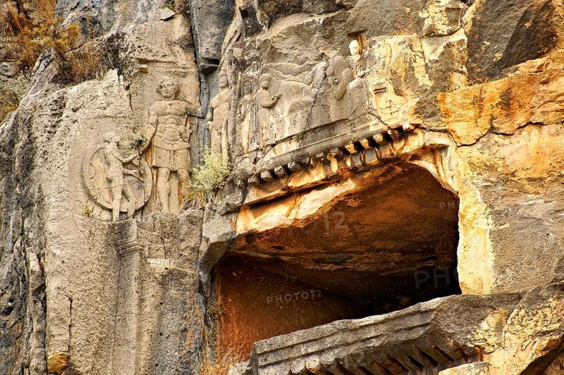 Pictures & images of the ancient Lycian rock cut tomb of a Gladiator whose rock relief sculpture can be seen with his family, Myra, Anatolia, Turkey, Asia