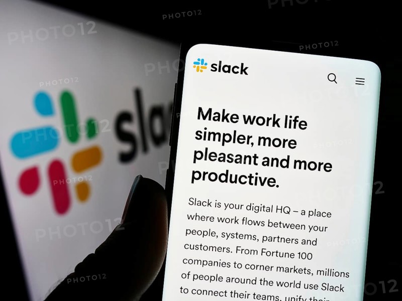 Stuttgart, Germany, 12-30-2022: Person holding cellphone with webpage of US software company Slack Technologies LLC on screen in front of logo. Focus on center of phone display, Europe