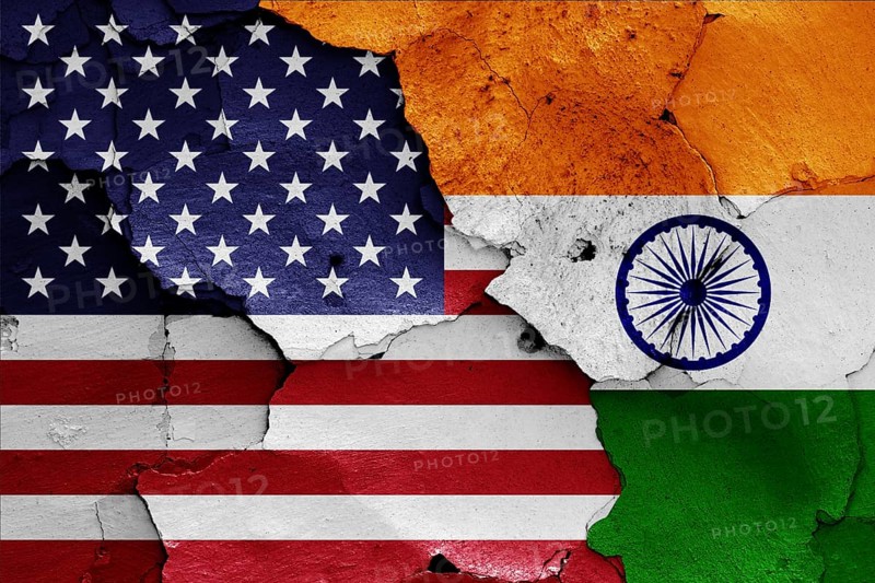 Flags of USA and India painted on cracked wall