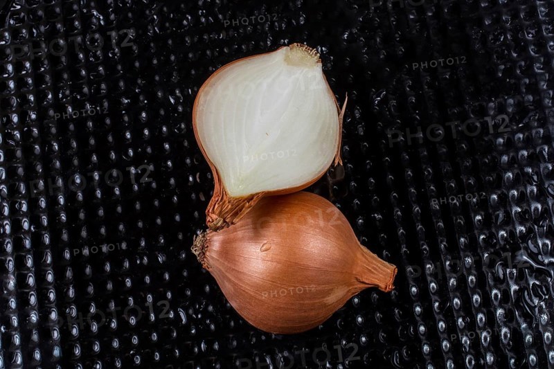 Onion bulb cut in half on a background