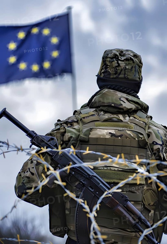 Symbolic image for the threat of war in the EU, a soldier in full combat gear stands in front of an EU flag, behind him a barbed wire fence, AI generated, AI generated