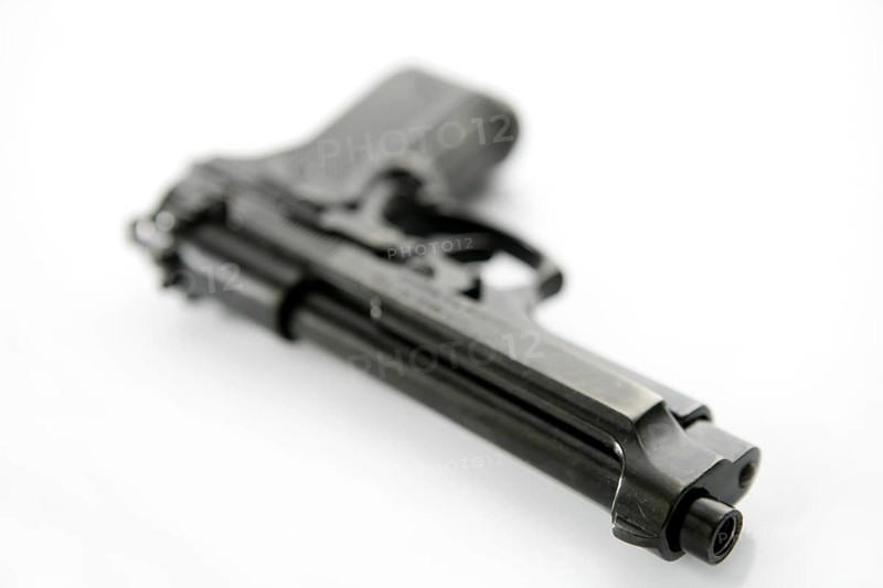 Black hand gun pistol over white background, selective focus, studio shot