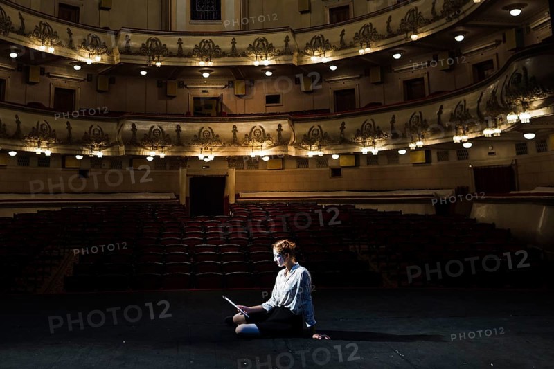 Mime reading manuscript stage empty auditorium. High resolution photo