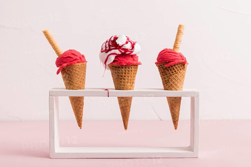 Red ice cream scoop cones with syrup waffle straw stand. High resolution photo