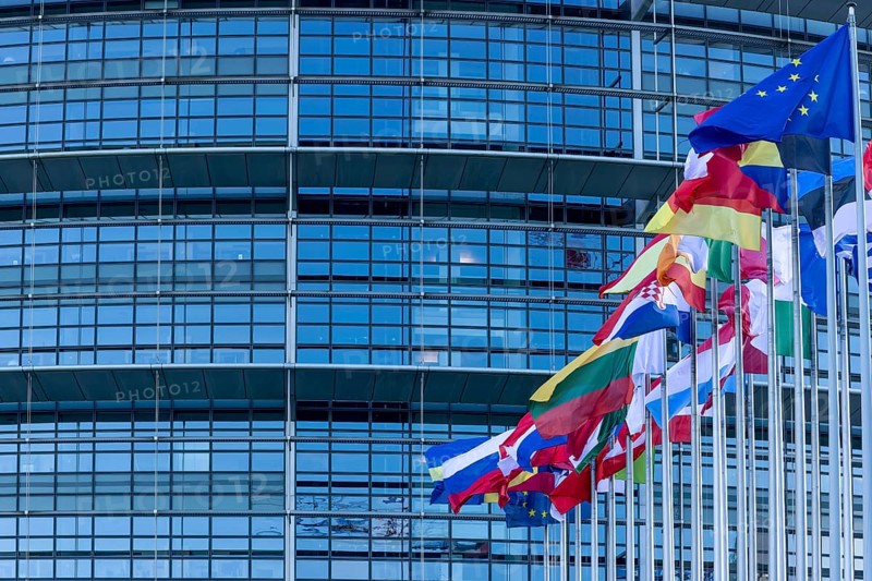 EU flags on poles in front of the Glass Fasadz building and the entrance to the European Parliament, European Parliament, Strasbourg, Alsace, Département Bas-Rhin, France, Europe