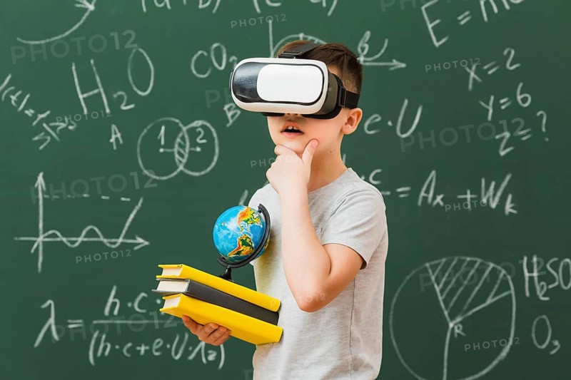 Side view boy wearing virtual reality headset holding books