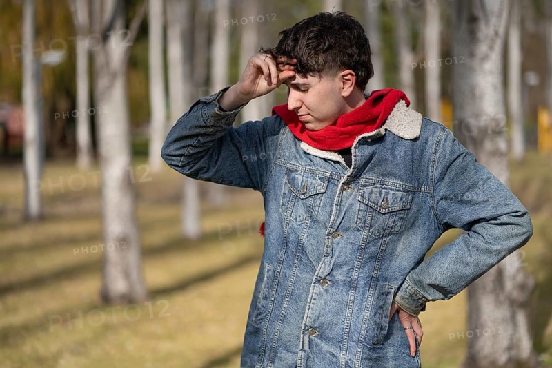 Stressed and tired young man touches his head because of a headache
