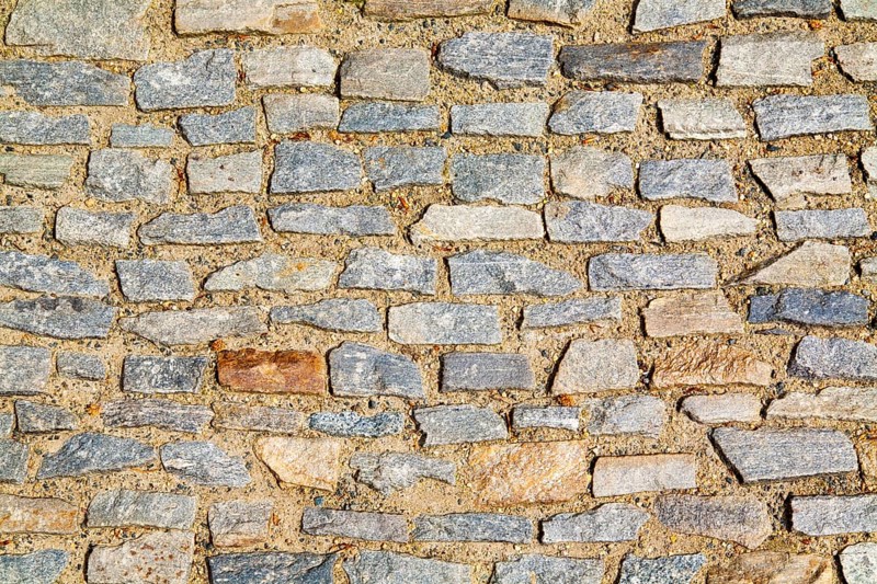 Stone pavement texture. Granite cobblestoned pavement background. Abstract background of old cobblestone pavement close-up