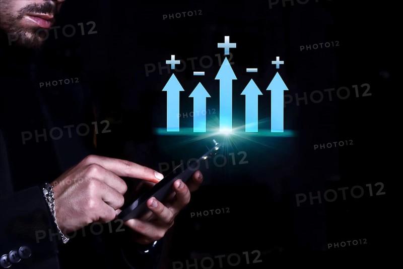 Businessman consulting his mobile phone observing the statistics and monetary balance of his company and the market.